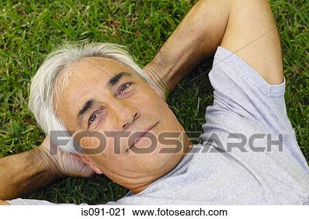 Man lying on grass View Large Photo Image Stock Image - Man lying on grass. Fotosearch