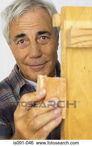 Stock Photograph - Man sanding wood. Fotosearch