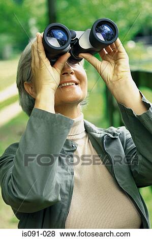 Woman looking through binoculars View Large Photo Image Stock Photo - Woman looking through binoculars. Fotosearch
