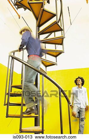 Man going up spiral stairs View Large Photo Image Stock Image - Man going up spiral stairs. Fotosearch