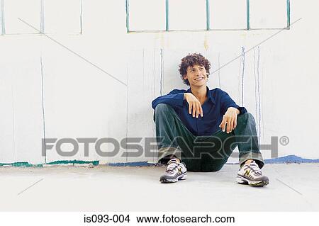 Man sitting against fence View Large Photo Image Picture - Man sitting against fence. Fotosearch