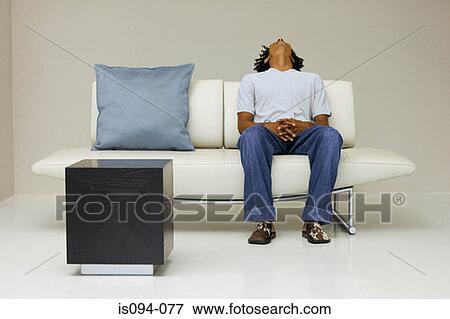 Stock Photo - Man relaxing on modern sofa. Fotosearch