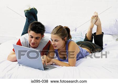 Teenage boy and girl on laptop computer View Large Photo Image Stock Photo - Teenage boy and girl on laptop computer. Fotosearch