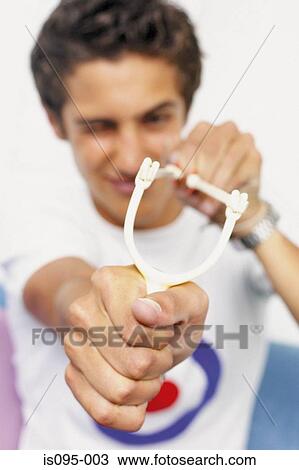 Stock Image - Teenage boy with catapult. Fotosearch