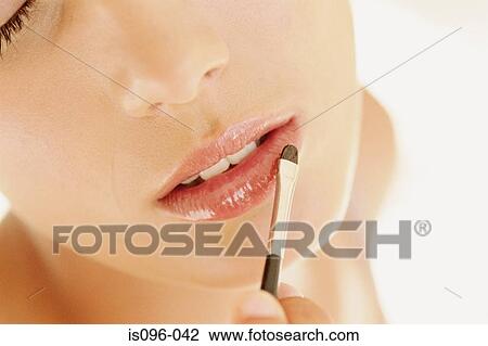 Stock Image - Woman applying lip gloss. Fotosearch