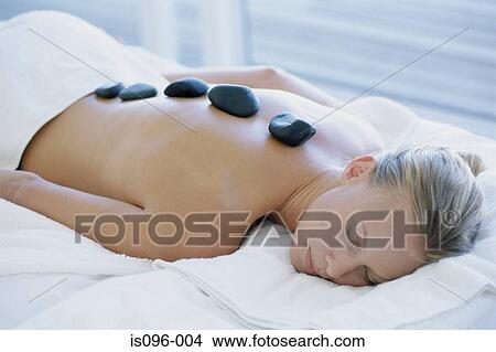Woman receiving hot rock treatment View Large Photo Image Picture - Woman receiving hot rock treatment. Fotosearch
