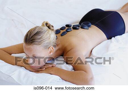 Woman receiving hot rock treatment View Large Photo Image Picture - Woman receiving hot rock treatment. Fotosearch