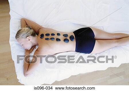 Woman receiving hot rock treatment View Large Photo Image Picture - Woman receiving hot rock treatment. Fotosearch