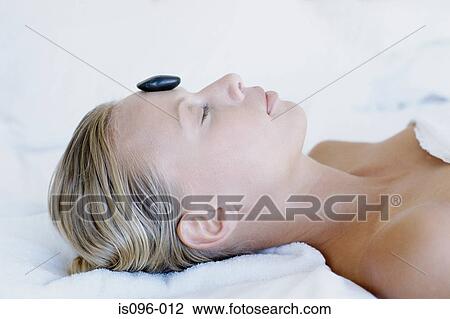 Stock Image - Woman receiving hot rock treatment. Fotosearch