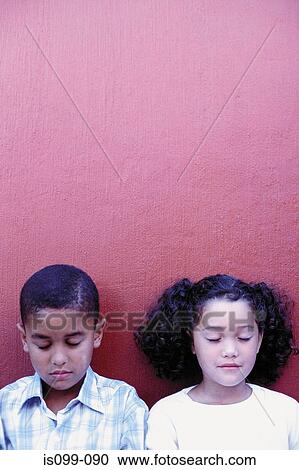 Stock Image - Boy and girl against wall. Fotosearch