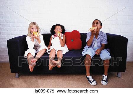 Boy and girl eating on sofa View Large Photo Image Stock Photography - Boy and girl eating on sofa. Fotosearch
