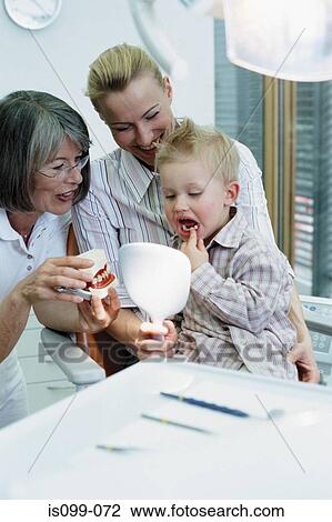 Stock Image - Boy being examined by dentist. Fotosearch