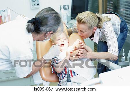 Stock Photo - Boy being examined by dentist. Fotosearch