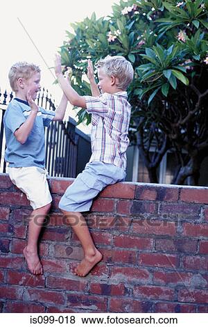 Boys playing on wall View Large Photo Image Stock Photo - Boys playing on wall. Fotosearch