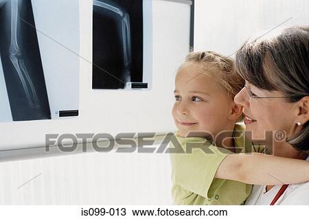 Girl and mother examining x-ray View Large Photo Image Stock Image - Girl and mother examining x-ray. Fotosearch