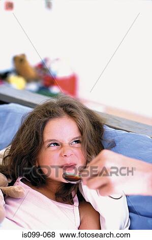 Girl being given medicine View Large Photo Image Stock Photo - Girl being given medicine. Fotosearch