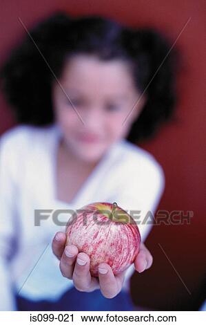 Girl offering an apple View Large Photo Image Stock Image - Girl offering an apple. Fotosearch