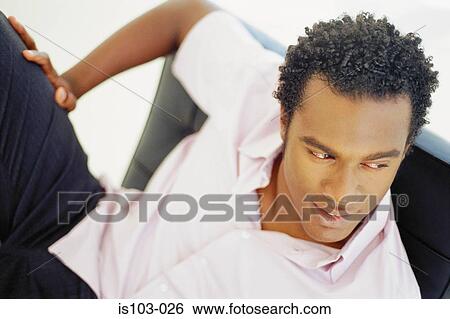 Portrait of businessman relaxing on a seat View Large Photo Image Stock Photograph - Portrait of businessman relaxing on a seat. Fotosearch