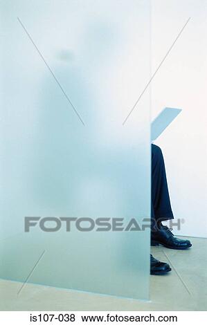 Stock Photo - Businessman seated on toilet with laptop computer. Fotosearch