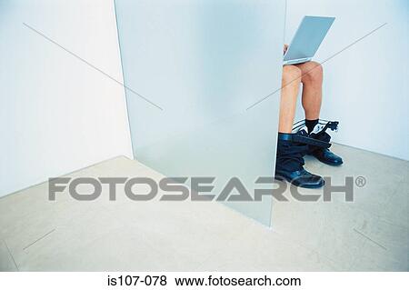 Businessman seated on toilet with laptop computer View Large Photo Image Stock Photo - Businessman seated on toilet with laptop computer. Fotosearch