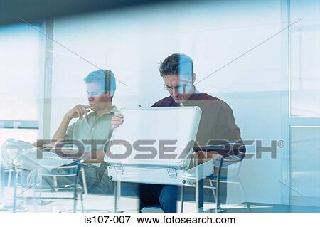 Stock Photo - Businessmen sitting behind glass pane. Fotosearch