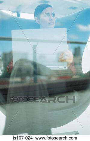 Businesswoman with laptop computer behind glass pane View Large Photo Image Picture - Businesswoman with laptop computer behind glass pane. Fotosearch