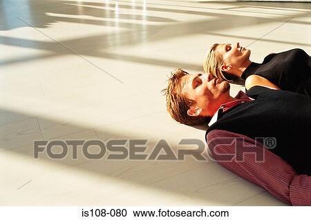 Businessman and businesswoman lying on floor View Large Photo Image Stock Image - Businessman and businesswoman lying on floor . Fotosearch