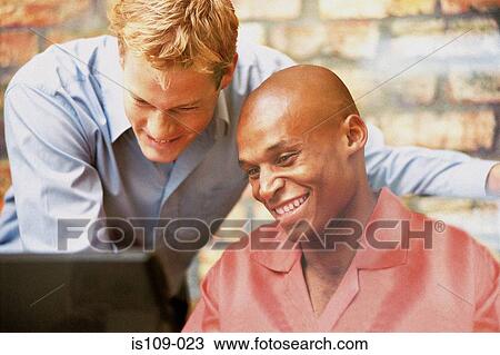 Stock Image - Businessmen working on computer. Fotosearch