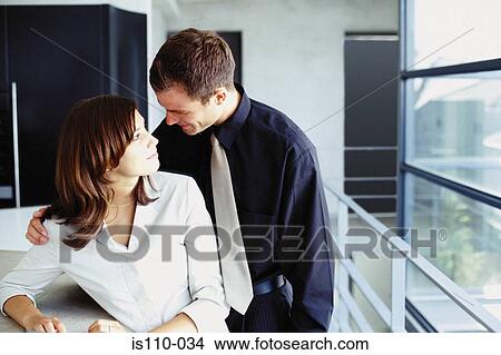 Man and woman cuddling in office View Large Photo Image Picture - Man and woman cuddling in office. Fotosearch