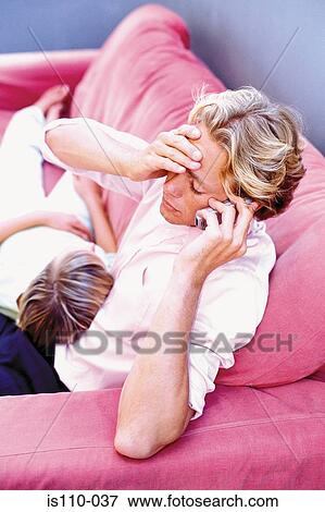 Stock Photo - Man and woman relaxing on sofa. Fotosearch