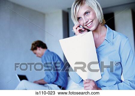 Stock Image - Man and woman working from bedroom. Fotosearch