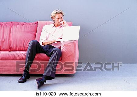 Man on sofa using laptop computer View Large Photo Image Stock Image - Man on sofa using laptop computer . Fotosearch