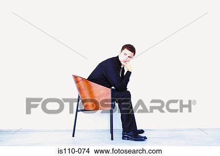 Man sitting on chair View Large Photo Image Picture - Man sitting on chair. Fotosearch