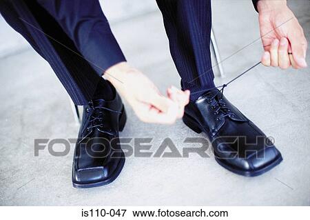 Man tying shoelaces View Large Photo Image Stock Photo - Man tying shoelaces. Fotosearch