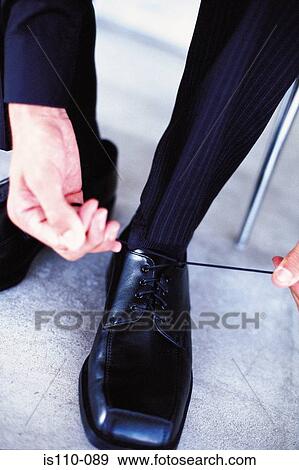 Man tying shoelaces View Large Photo Image Stock Photo - Man tying shoelaces. Fotosearch