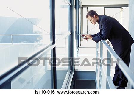 Stock Photograph - Man typing on personal organiser. Fotosearch