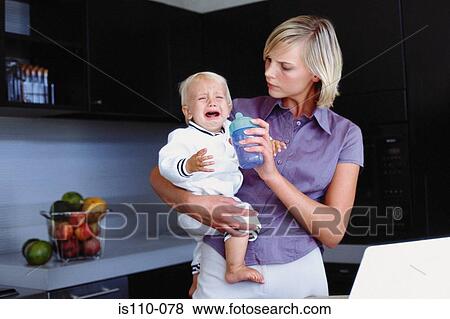 Woman and infant in kitchen View Large Photo Image Stock Photo - Woman and infant in kitchen. Fotosearch