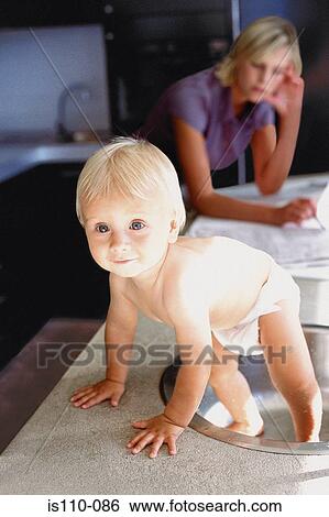 Woman and infant in kitchen View Large Photo Image Stock Photograph - Woman and infant in kitchen. Fotosearch