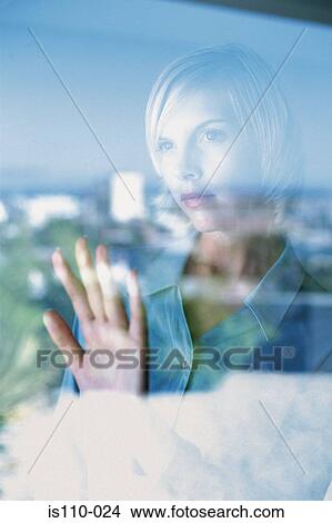 Picture - Woman behind glass pane. Fotosearch