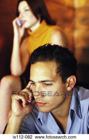 Stock Image - Man and woman talking on cellphone. Fotosearch