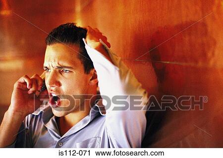 Stock Image - Man talking angrily on cellphone. Fotosearch