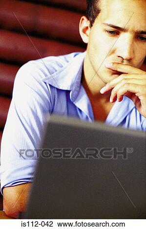 Stock Image - Man using laptop computer in bar. Fotosearch