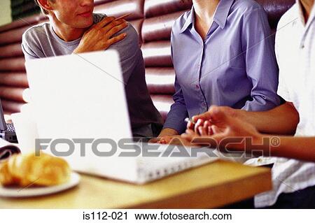 Stock Image - Men and woman discussing work at bar. Fotosearch