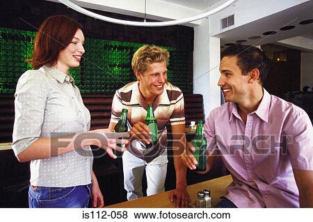 Men and woman having drink at bar View Large Photo Image Stock Photo - Men and woman having drink at bar. Fotosearch