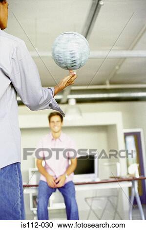 Stock Image - Men playing with ball in an office. Fotosearch