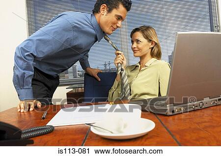 Stock Image - Businessman and businesswoman flirting. Fotosearch