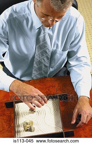 Businessman playing with executive toy View Large Photo Image Stock Photography - Businessman playing with executive toy. Fotosearch