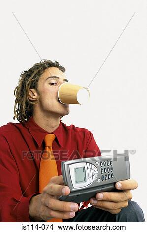 Businessman drinking coffee and using cellphone View Large Photo Image Picture - Businessman drinking coffee and using cellphone. Fotosearch