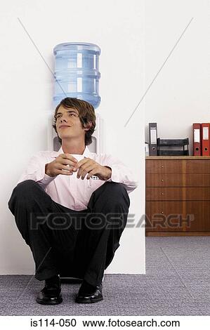 Stock Image - Businessman sitting next to mineral water. Fotosearch