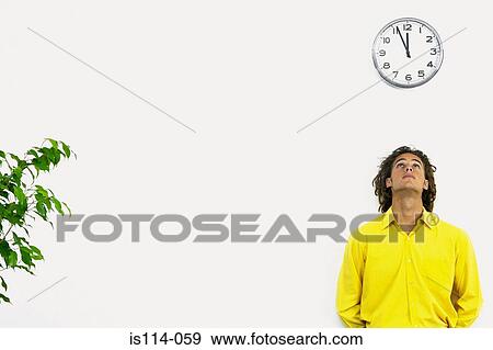 Businessman underneath wall clock View Large Photo Image Stock Photo - Businessman underneath wall clock. Fotosearch